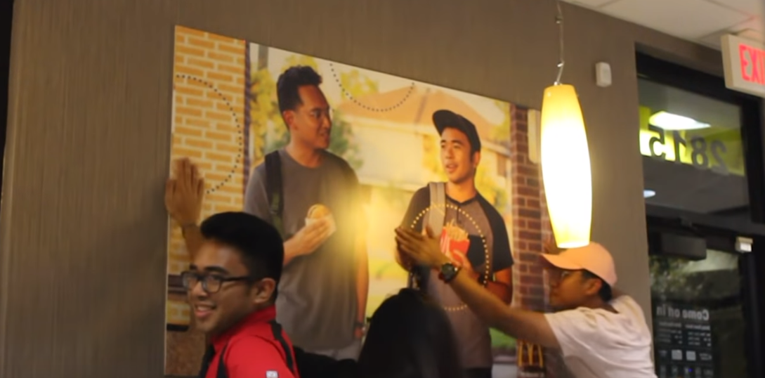 Jongens hangen foto van zichzelf op in de McDonald's