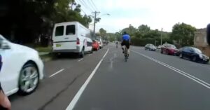 Wielrenner die fietspad niet wil gebruiken met pijnlijk kennis met aanhangwagen